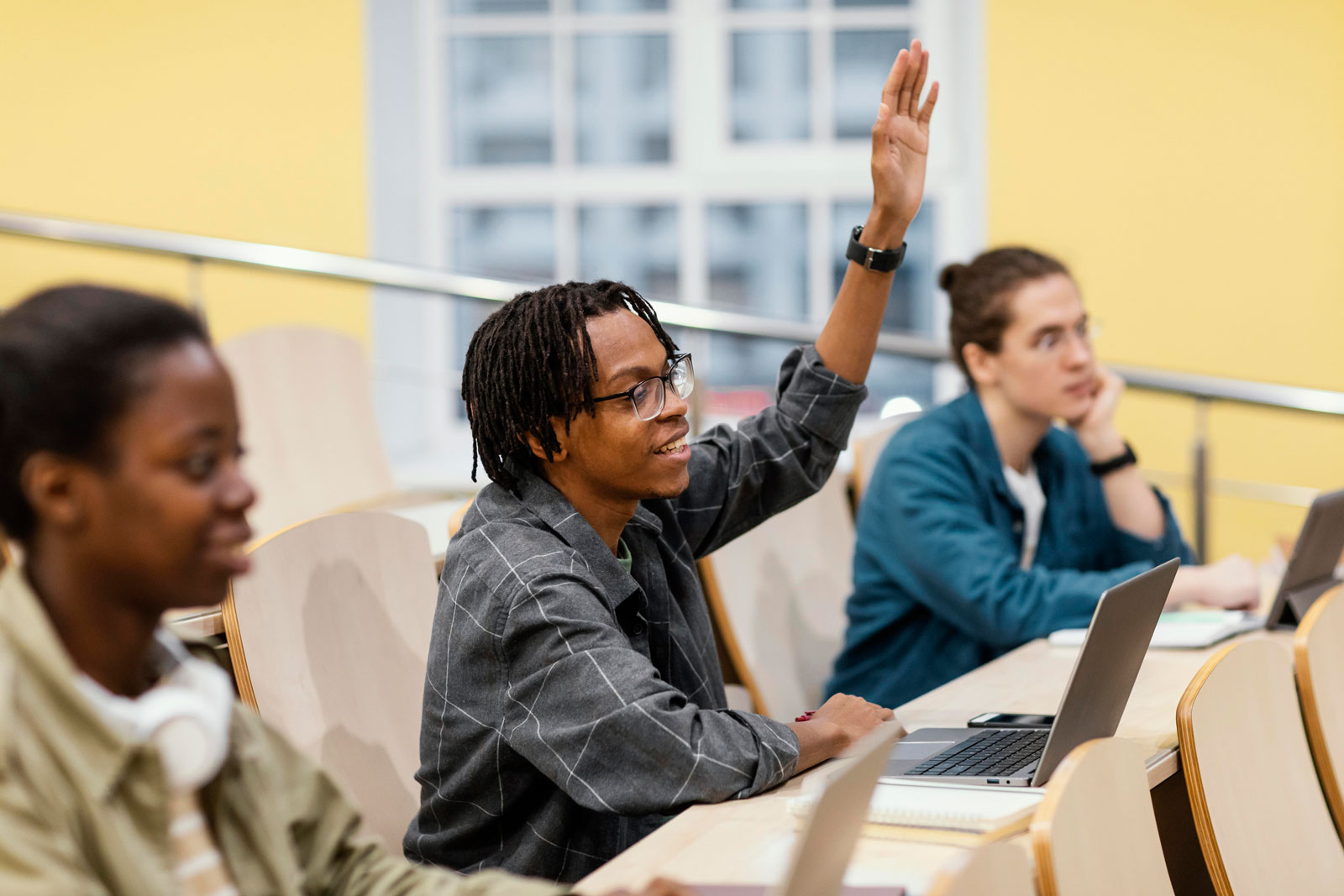 Male student raising his hand in class